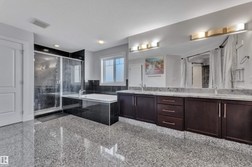 Spacious bathroom featuring a large soaking tub, separate glass-enclosed shower, dual vanity with undermount sinks, and extensive counter space - 10915 175 Avenue Nw, Edmonton, AB - Indoor