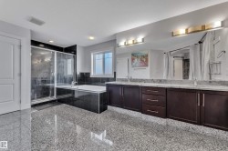 Spacious bathroom featuring a large soaking tub, separate glass-enclosed shower, dual vanity with undermount sinks, and extensive counter space - 