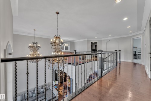 Hardwood-finish flooring, recessed lighting, crown molding, and wrought iron balusters - 10915 175 Avenue Nw, Edmonton, AB - Indoor Photo Showing Other Room