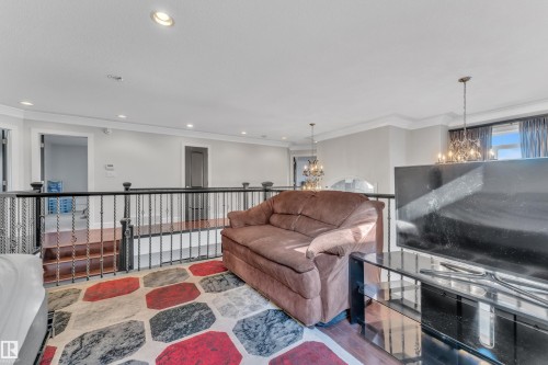 Open loft space with black wrought iron railing, recessed lighting, and crown molding - 10915 175 Avenue Nw, Edmonton, AB - Indoor