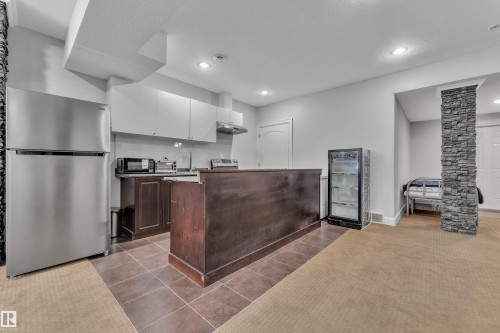 Kitchenette with stainless steel refrigerator, dark wood-finish cabinetry, and recessed lighting - 10915 175 Avenue Nw, Edmonton, AB - Indoor Photo Showing Kitchen