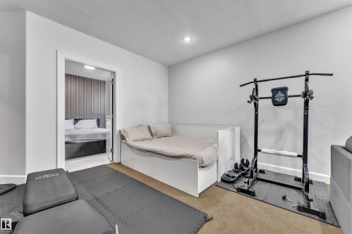 Recessed lighting illuminates this versatile room with carpet flooring, featuring a built-in daybed and a doorway - 10915 175 Avenue Nw, Edmonton, AB - Indoor