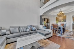 Hardwood-style flooring throughout, arched entryway, tray ceiling with chandelier, and built-in cabinetry - 
