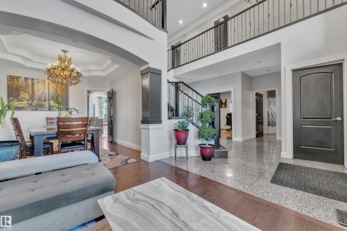 Two-story foyer with tile flooring, dark wood-finish flooring, and an open second-story walkway with wrought iron railing - 10915 175 Avenue Nw, Edmonton, AB - Indoor Photo Showing Living Room