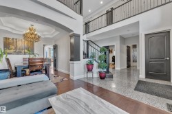 Two-story foyer with tile flooring, dark wood-finish flooring, and an open second-story walkway with wrought iron railing - 