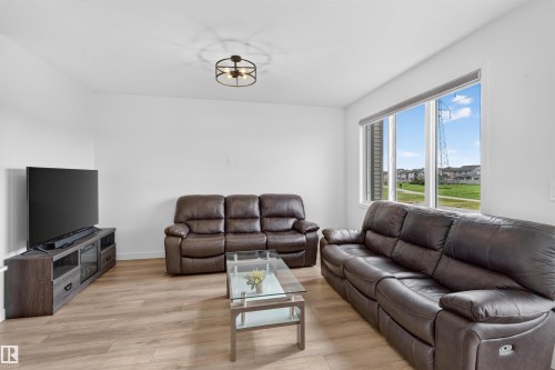 Wood-finish flooring with white walls and a large window - 1676 27 Street Nw, Edmonton, AB 