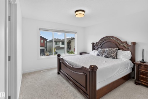 Wall-to-wall carpeting and a wide window offering abundant natural light - 1676 27 Street Nw, Edmonton, AB 