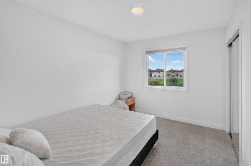 Recessed ceiling light fixture, white walls, gray carpet, white window frame, and sliding closet doors - 1676 27 Street Nw, Edmonton, AB 