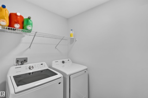 Laundry area with built-in wire shelving and white walls - 1676 27 Street Nw, Edmonton, AB 