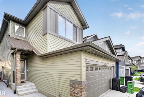 Two-story exterior with light green siding and dark trim - 1676 27 Street Nw, Edmonton, AB 