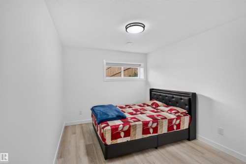 Recessed ceiling light, flush-mount ceiling light, white walls, wood-finish flooring, and a window with natural light - 1676 27 Street Nw, Edmonton, AB 