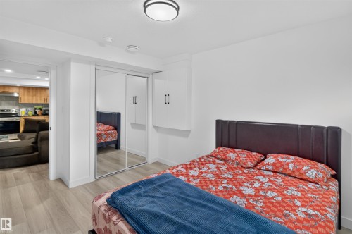 Wood-finish flooring, mirrored sliding closet doors, and a built-in wall cabinet - 1676 27 Street Nw, Edmonton, AB 