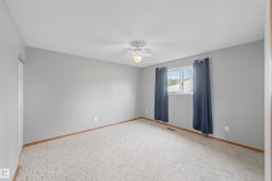 Neutral wall paint, light-toned carpeting, ceiling fan with integrated lighting, and a large window - 