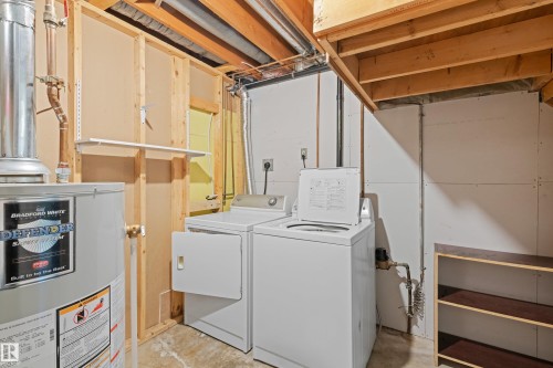 Laundry area with a water heater, clothes washer, and dryer - 14538 37 Street Nw, Edmonton, AB 