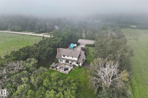 Two-story residence featuring a shingled roof, a chimney, and a rear deck with a pergola - #38 24512 Sturgeon Rd, Rural Sturgeon County, AB 
