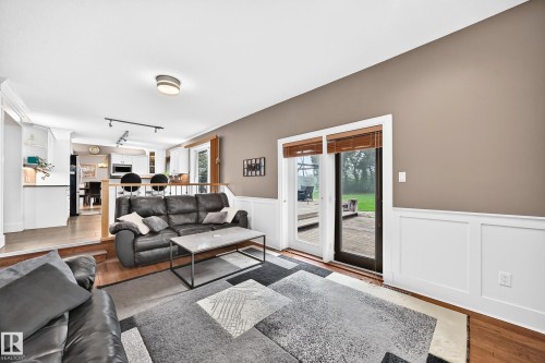 Hardwood-finish flooring, white wainscoting, and sliding glass doors to outdoor patio - #38 24512 Sturgeon Rd, Rural Sturgeon County, AB 