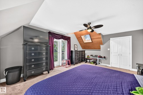 Sloped ceilings with wood paneling, ceiling fan, carpet flooring, a skylight, and white bi-fold closet doors - #38 24512 Sturgeon Rd, Rural Sturgeon County, AB 