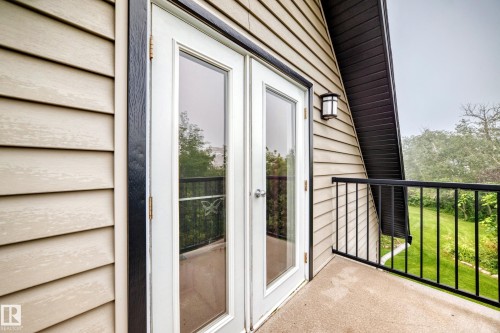 Balcony with concrete flooring, black metal railing, and glass-paneled French doors - #38 24512 Sturgeon Rd, Rural Sturgeon County, AB 