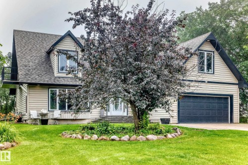 Siding exterior with dormer windows, attached garage, front yard landscaping, and a second-story balcony - #38 24512 Sturgeon Rd, Rural Sturgeon County, AB 