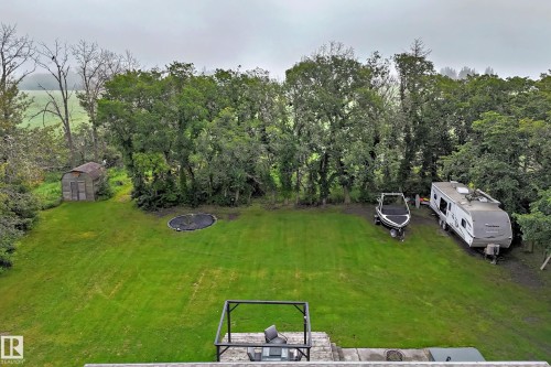 Expansive green lawn with mature trees bordering the property - #38 24512 Sturgeon Rd, Rural Sturgeon County, AB 