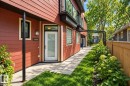 Siding exterior with a white entry door, an exterior wall sconce, and glass block windows - 10806 83 Avenue Nw, Edmonton, AB 