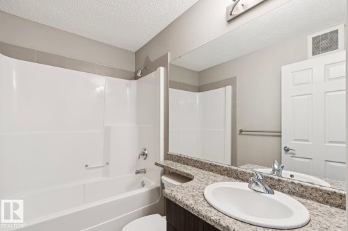 White tub and shower combination with chrome fixtures - 5409 3 Avenue Sw, Edmonton, AB - Indoor Photo Showing Bathroom