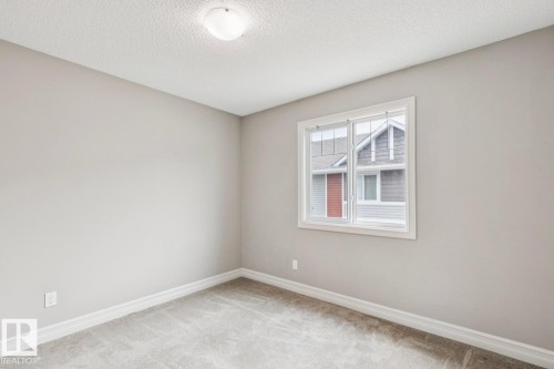 Neutral-toned walls, light-colored carpeting, and a white-framed window - 5409 3 Avenue Sw, Edmonton, AB - Indoor Photo Showing Other Room