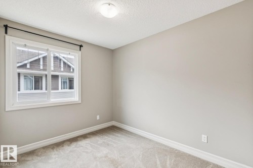 Wall-to-wall carpeting, neutral wall paint, white trim, single window, and a ceiling-mounted light fixture - 5409 3 Avenue Sw, Edmonton, AB - Indoor Photo Showing Other Room