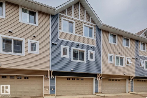 Two-story townhouse exterior with two-tone siding, multiple windows, and an attached garage - 5409 3 Avenue Sw, Edmonton, AB - Outdoor