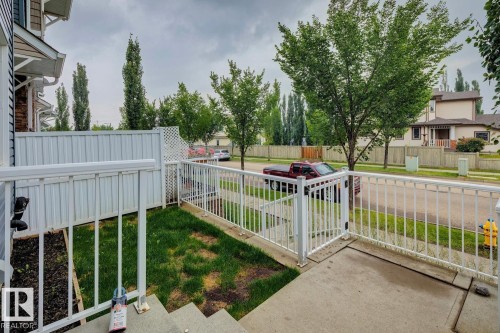 Front patio with white railings, concrete steps, and a grassy area - 5409 3 Avenue Sw, Edmonton, AB - Outdoor