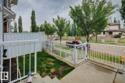Front patio with white railings, concrete steps, and a grassy area - 