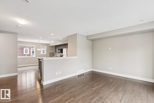 Wood-finish flooring, recessed lighting, and a half-wall partition - 5409 3 Avenue Sw, Edmonton, AB - Indoor Photo Showing Other Room
