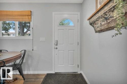 White paneled door with an arched window, light gray walls, and vinyl plank flooring - #138 5231 51 St, Bon Accord, AB - Indoor Photo Showing Other Room