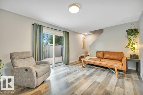 Vinyl plank flooring, light grey wall paint, and a sliding glass door to the exterior - #138 5231 51 St, Bon Accord, AB - Indoor Photo Showing Living Room