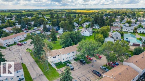 Aerial perspective showcasing a residential community with mature trees and visible rooftops - #138 5231 51 St, Bon Accord, AB - Outdoor With View