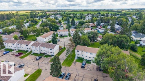 Townhome residences with individual parking spaces, surrounded by mature trees, and land - #138 5231 51 St, Bon Accord, AB - Outdoor With View
