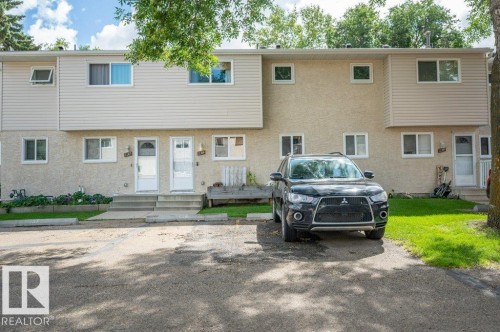 Two-story exterior with light-colored siding and stucco, featuring multiple windows.  2 parking stalls for the unit - #138 5231 51 St, Bon Accord, AB - Outdoor