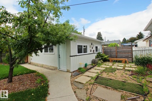 Private concrete walkway leading to a secondary structure with white exterior siding and multiple windows - 5712 113B Street Nw, Edmonton, AB - Outdoor