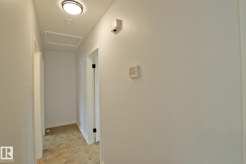 Hallway featuring a flush-mount ceiling light, light-toned wall paint, and wood-finish flooring - 5712 113B Street Nw, Edmonton, AB - Indoor Photo Showing Other Room