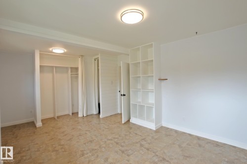 Recessed closet space with built-in shelving, integrated ceiling lighting, and tile flooring - 5712 113B Street Nw, Edmonton, AB - Indoor Photo Showing Other Room