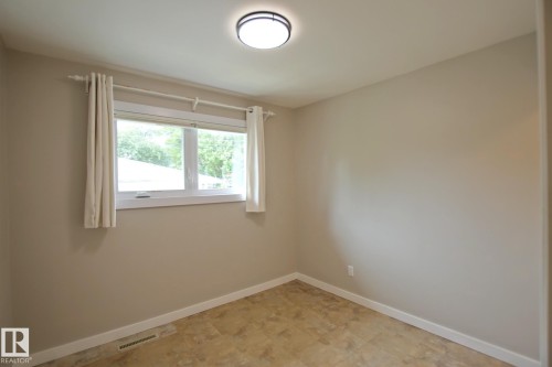 Neutral wall color, light-toned tiled flooring, white trim, and a flush mount ceiling light fixture - 5712 113B Street Nw, Edmonton, AB - Indoor Photo Showing Other Room