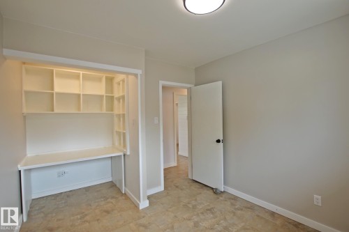 Built-in shelving with integrated desk, flush-mount ceiling light, and neutral wall paint - 5712 113B Street Nw, Edmonton, AB - Indoor Photo Showing Other Room
