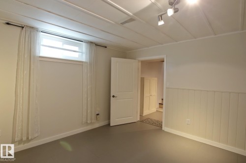 Recessed window, white trim, track lighting, beadboard wainscoting, and a paneled interior door - 5712 113B Street Nw, Edmonton, AB - Indoor Photo Showing Other Room