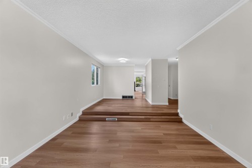 Wood-finish flooring with a two-step elevation - 14725 43A Avenue Nw, Edmonton, AB - Indoor Photo Showing Other Room