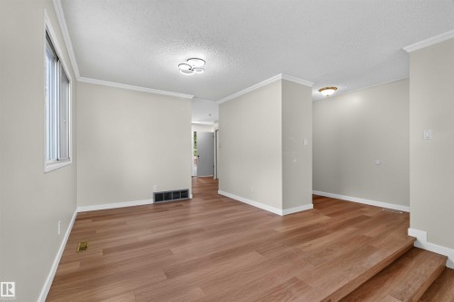 Wood-finish flooring, white trim, neutral wall color, contemporary ceiling fixture, and a window providing natural light - 14725 43A Avenue Nw, Edmonton, AB - Indoor Photo Showing Other Room