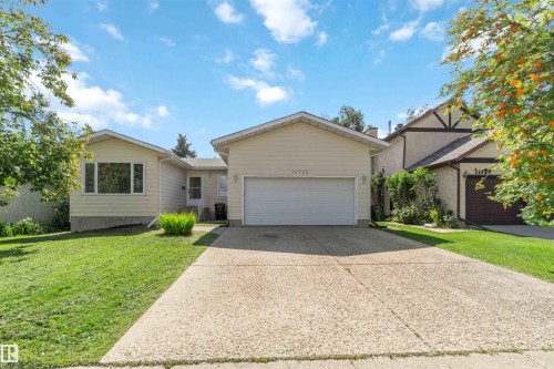 Single-story residence featuring a two-car garage, expansive concrete driveway, and front lawn - 14725 43A Avenue Nw, Edmonton, AB - Outdoor With Facade