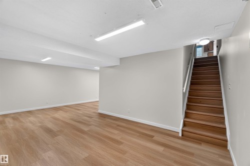 Spacious finished room with wood-finish flooring, white walls, and bright overhead lighting - 14725 43A Avenue Nw, Edmonton, AB - Indoor Photo Showing Other Room