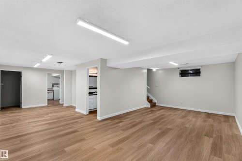 Expansive open room featuring wood-finish flooring, recessed lighting, a utility area, and a secondary space - 14725 43A Avenue Nw, Edmonton, AB - Indoor