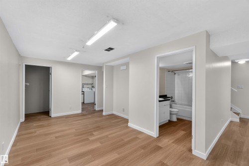 Neutral-toned walls complement wood-finish flooring - 14725 43A Avenue Nw, Edmonton, AB - Indoor Photo Showing Other Room