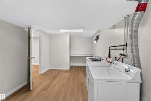 Laundry area featuring wood-finish flooring, a utility sink, and ample counter space - 14725 43A Avenue Nw, Edmonton, AB - Indoor Photo Showing Laundry Room